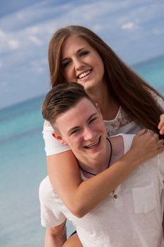 smiling young couple having fun in summer on the beach