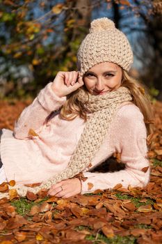 young smiling woman with hat and scarf outdoor in autumn nature background