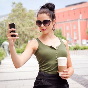 attractive young woman with smartphone and sunglasses outdoor in summer