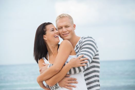 smiling young couple having fun in summer on the beach