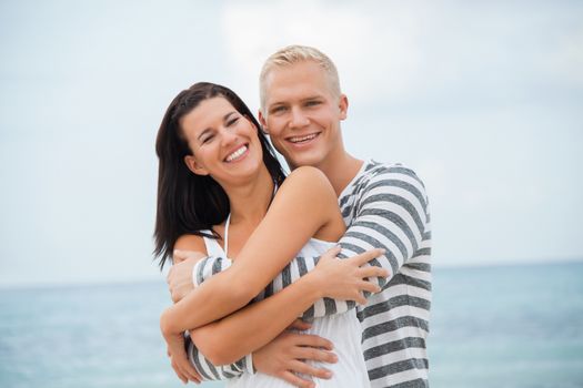 smiling young couple having fun in summer on the beach