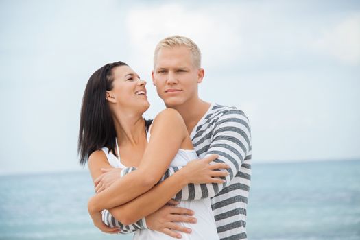 smiling young couple having fun in summer on the beach