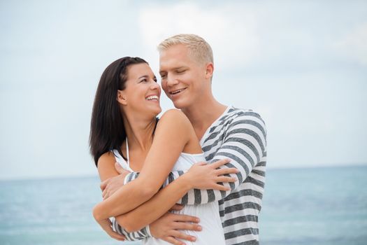 smiling young couple having fun in summer on the beach