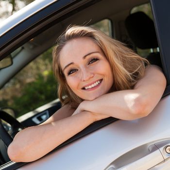 young attractive happy woman sitting in car summer portrait outdoor