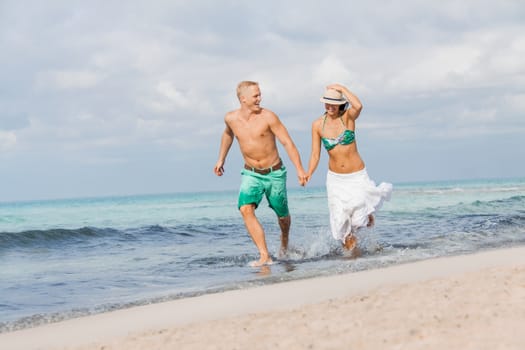 young happy couple walking on beach sunset holiday vacation