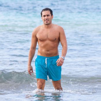 attractive young athletic man on the beach in summer outdoor vacation