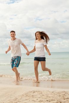 happy young couple on the beach in summer holiday love togetherness