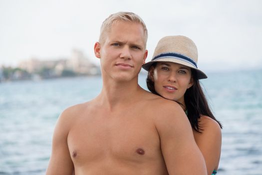 smiling young couple having fun in summer on the beach