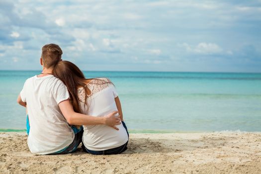 romantic young couple sitting on the beach in summer holiday 