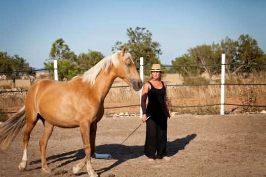 young woman training horse outside in summer choreography 