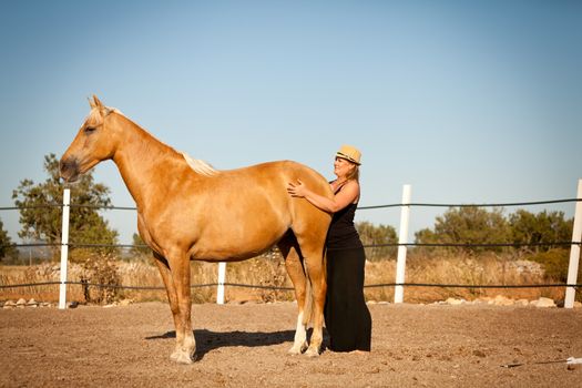 young woman training horse outside in summer choreography 