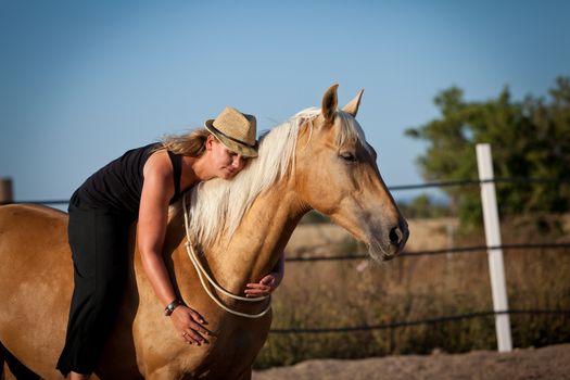 young woman training horse outside in summer choreography 