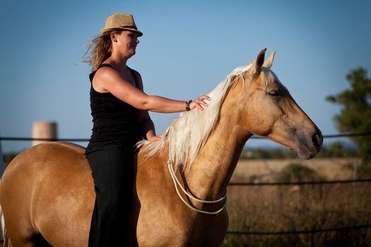 young woman training horse outside in summer choreography 