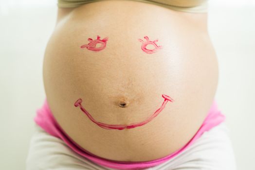 Smile Paint on pregnant woman abdomen, belly
