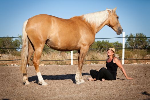 young woman training horse outside in summer choreography 
