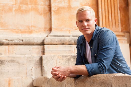 junger erwachsener mann mit blonden haaren im sommer im freien portrait