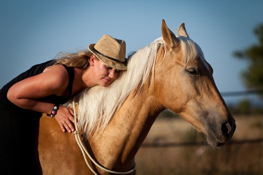 young woman training horse outside in summer choreography 
