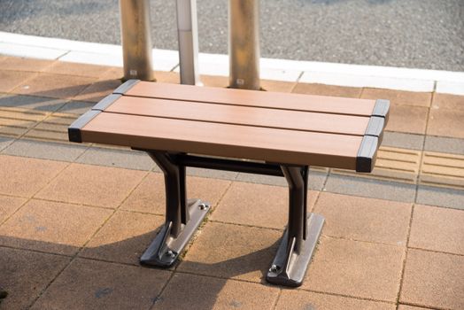 Chair was attached to the sidewalk, for waiting for the bus