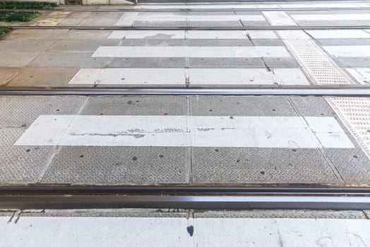 Rail of the tram lean together with crosswalk on the street