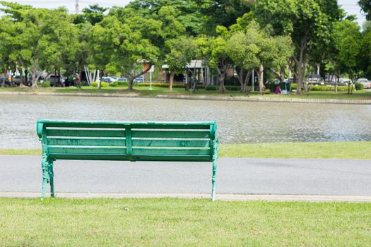 bench in park by a pond in the background, thailand