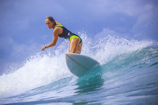 Surfer girl on Amazing Blue Wave, Bali island.