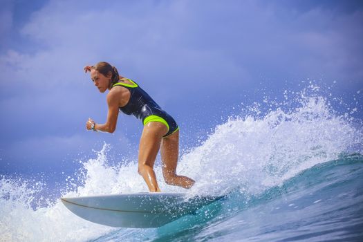 Surfer girl on Amazing Blue Wave, Bali island.