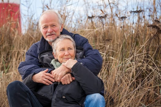 happy mature couple relaxing baltic sea dunes in autumn