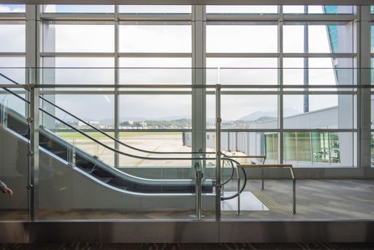 The airport escalator that have view through the glass to the outside