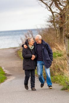 happy mature couple relaxing baltic sea dunes in autumn