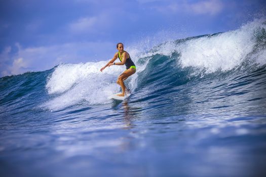 Surfer girl on Amazing Blue Wave, Bali island.