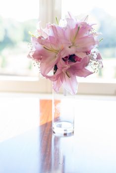 Pink Lily flower in glass jar placed by the elegant look window vintage style