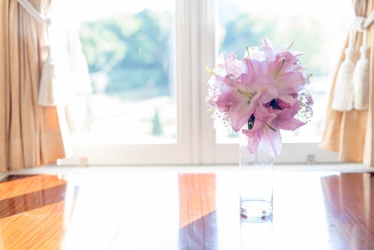 Pink Lily flower in glass jar placed by the elegant look window vintage style