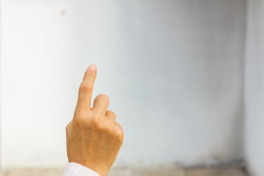 Hand simulating pressing a button on blank white wall