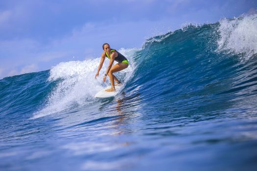 Surfer girl on Amazing Blue Wave, Bali island.