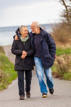 happy mature couple relaxing baltic sea dunes in autumn