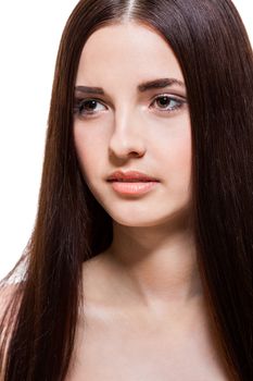 Beautiful serene young woman with a gentle expression, bare shoulders and long straight brown hair looking calmly at the camera , close up side view with turned head isolated on white