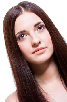 Beautiful serene young woman with a gentle expression, bare shoulders and long straight brown hair looking calmly at the camera , close up side view with turned head isolated on white