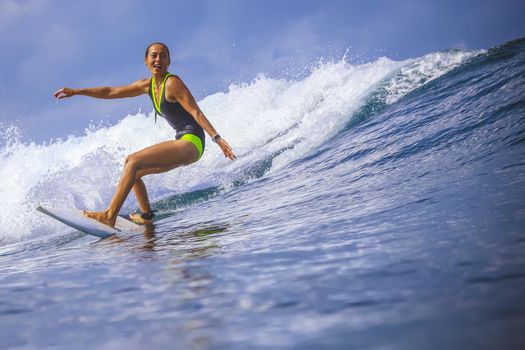 Surfer girl on Amazing Blue Wave, Bali island.