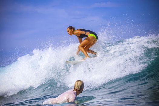 Surfer girl on Amazing Blue Wave, Bali island.