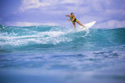 Surfer girl on Amazing Blue Wave, Bali island.