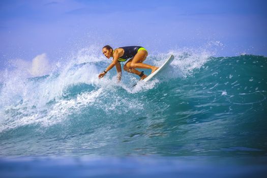 Surfer girl on Amazing Blue Wave, Bali island.