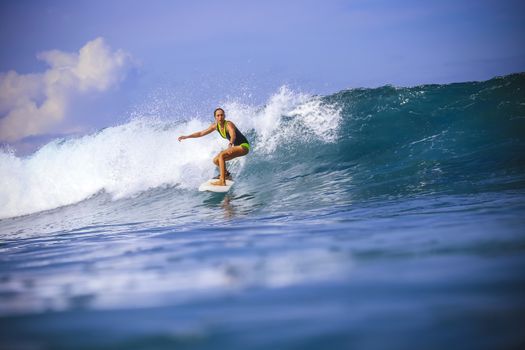 Surfer girl on Amazing Blue Wave, Bali island.