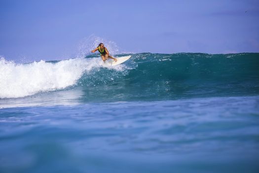 Surfer girl on Amazing Blue Wave, Bali island.