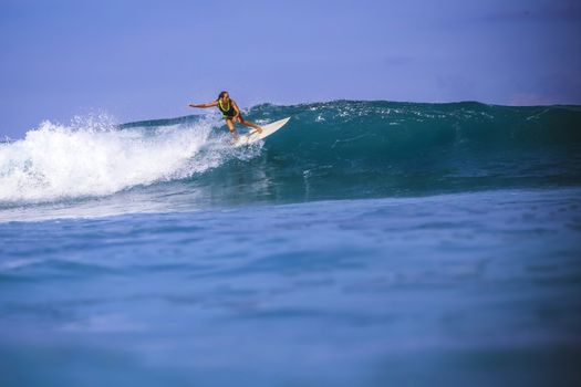 Surfer girl on Amazing Blue Wave, Bali island.