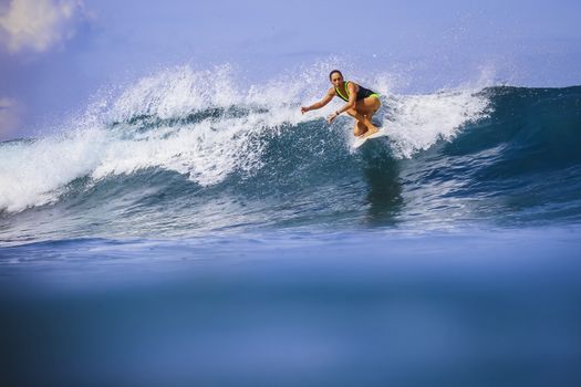 Surfer girl on Amazing Blue Wave, Bali island.