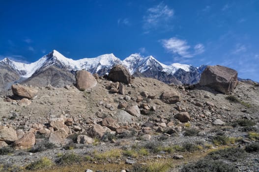 Rocks on the edge of Engilchek glacier with picturesque Tian Shan mountain range in Kyrgyzstan