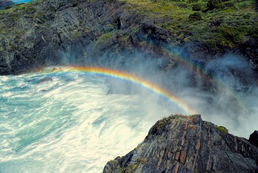 Rainbow over waterfall in Torres del Paine in south American Andes                   