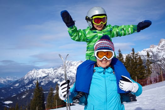 Ski, winter, snow, skiers, sun and fun - Family - mother and son enjoying winter vacations.