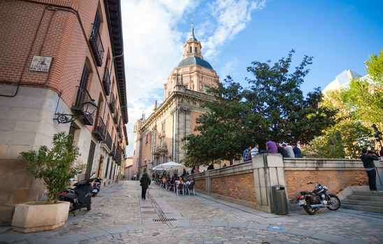 Madrid, Spain - May 6, 2012: San Andres Church on a sunny spring day with tourists and local people in frot in Madrid, Spain