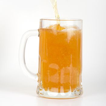 beer is pouring into glass on white background